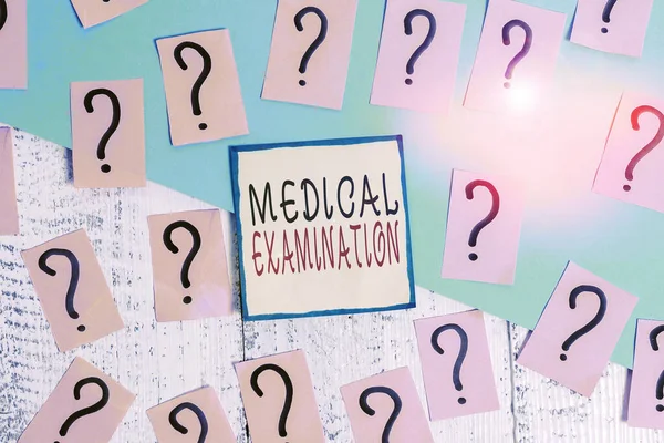 Handwriting text writing Medical Examination. Concept meaning Checkup carried out to determine the physical fitness Scribbled and crumbling papers with thick cardboard above wooden table.