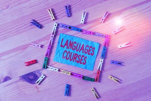 Conceptual hand writing showing Languages Courses. Business photo text set of classes or a plan of study on a foreign language Colored crumpled papers wooden floor background clothespin.