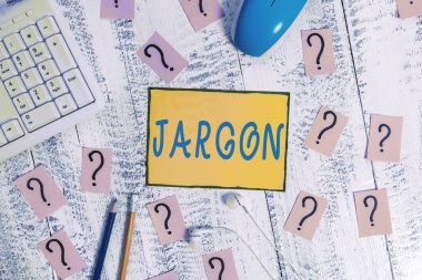 Text sign showing Jargon. Conceptual photo special words or expressions that are used by a particular profession Writing tools, computer stuff and scribbled paper on top of wooden table. clipart
