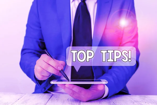 Text sign showing Top Tips. Conceptual photo small but particularly useful piece of practical advice Businessman pointing with pen in empty copy space.