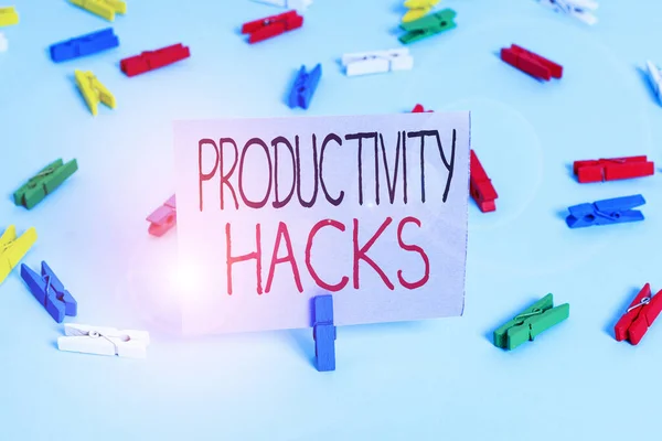 Handstil text skriva produktivitet Hacks. Begreppet innebär trick som du får mer gjort på samma tid Färgade klädnypor tomma påminnelse blå golv bakgrund office pin. — Stockfoto