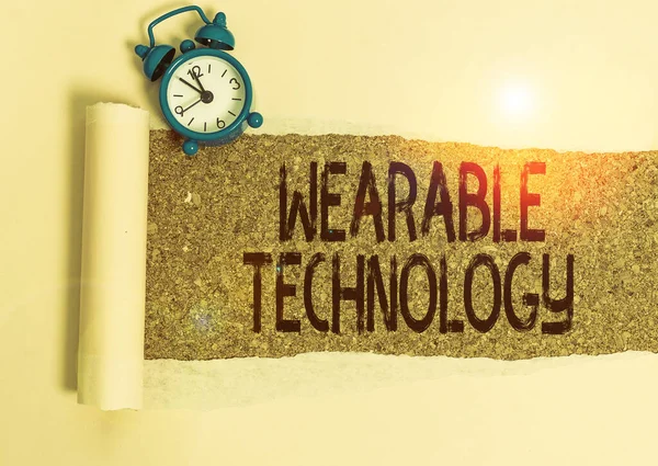 Writing note showing Wearable Technology. Business photo showcasing electronic devices that can be worn as accessories Alarm clock and torn cardboard on a wooden classic table backdrop.
