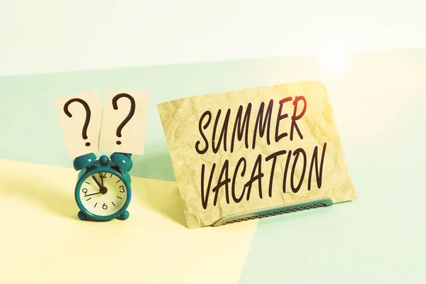 Word writing text Summer Vacation. Business concept for the time when children do not go to school in the summer Mini size alarm clock beside a Paper sheet placed tilted on pastel backdrop.