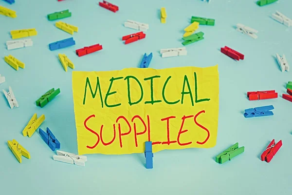 Handwriting text writing Medical Supplies. Concept meaning Items necessary for treatment of illness or injury Colored clothespin papers empty reminder blue floor background office pin.