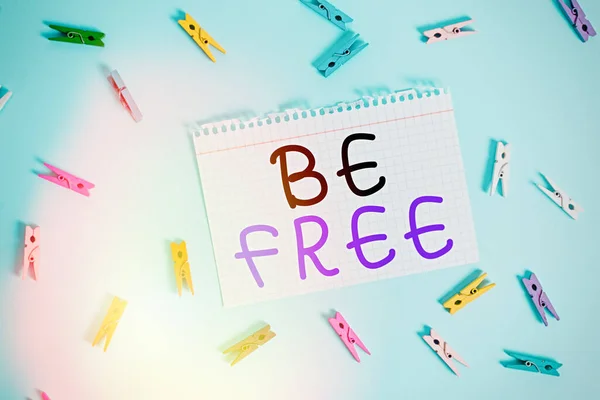 Writing note showing Be Free. Business photo showcasing ability to do whatever you want without limitations or controls Colored clothespin rectangle shaped paper blue background.