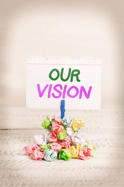 Text sign showing Our Vision. Conceptual photo serves as clear guide for choosing current and future actions Reminder pile colored crumpled paper clothespin reminder white wooden space.