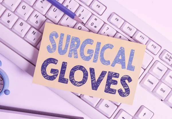 Writing note showing Surgical Gloves. Business photo showcasing to protect from the exposure to infectious materials White pc keyboard note paper and paper clips above white background.