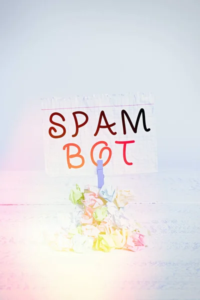 Написання тексту Spam Bot. Концепція означає автономну програму в Інтернеті, яка відправляє спам користувачам Reminder купа кольорових зморшкуватих паперових сховищ, нагадуючи білий дерев'яний простір. — стокове фото