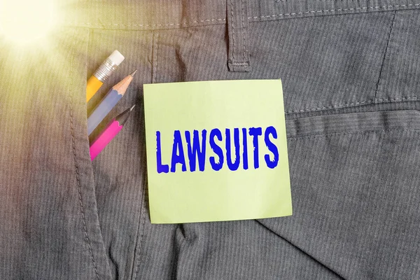 Writing note showing Lawsuits. Business photo showcasing a claim or dispute brought to a law court for adjudication Writing equipment and green note paper in pocket of trousers. — Stock Photo, Image