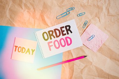 Yemek siparişini gösteren kavramsal el yazısı. İş fotoğrafı, restorandaki Papercraft masa karesinin sarmal not defteri çalışma malzemelerine tercih edilen yiyecekleri talep etme sürecine gönderilir..