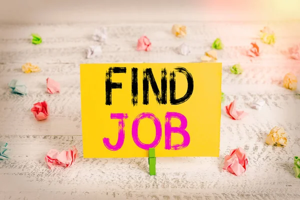 Text sign showing Find Job. Conceptual photo An act of demonstrating to find or search work suited for his profession Green clothespin white wood background colored paper reminder office supply.