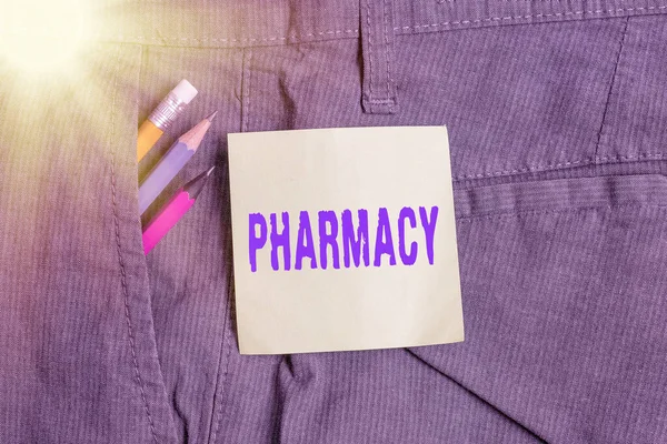 Escribiendo nota mostrando Farmacia. Tienda de fotografía comercial o dispensario de hospital donde se venden medicamentos Equipo de escritura y papel de nota verde en el bolsillo de los pantalones . —  Fotos de Stock