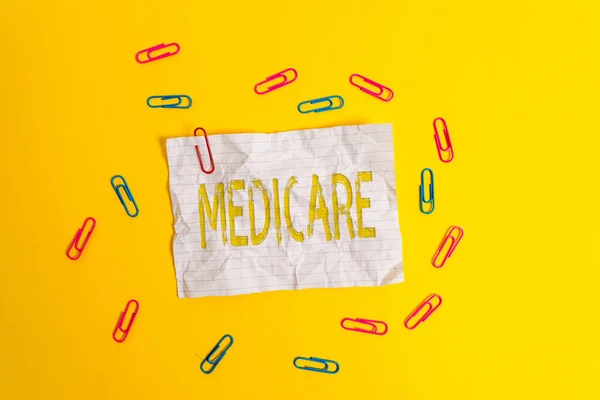 Handwriting text Medicare. Concept meaning the federal government plan in US for paying certain hospital Blank crushed paper sheet message clips binders plain colored background.