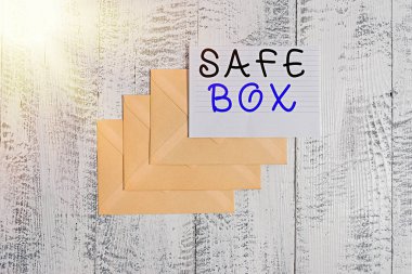 El yazısı Güvenli Kutusu. Kavram, önemli ya da değerli şeyleri tutabileceğiniz küçük bir yapı demek. Yöneten üç zarf, eski ahşap bir arka plan..