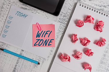 Wifi Zone el yazısı. Kavram anlamı kablosuz yüksek hız internet ve ağ bağlantıları sağlar Kare spiral not defteri akıllı telefon kağıt toplar ataç ahşap.