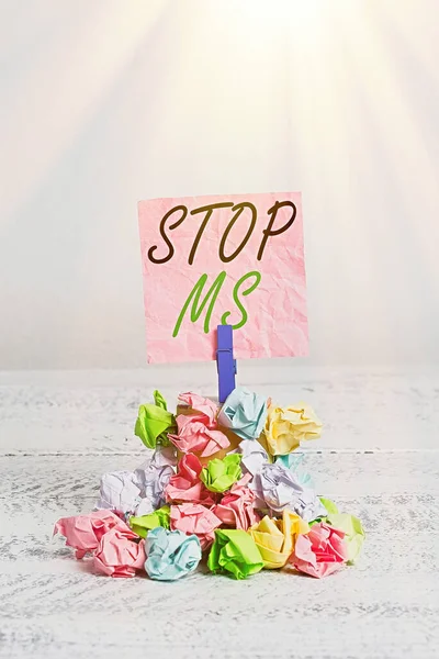 Conceptual hand writing showing Stop Ms. Business photo text treat the condition that can affect the brain and spinal cord Reminder pile colored crumpled paper clothespin wooden space.