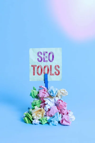 Seo Tools-t ábrázoló üzenet. Fogalmi fotó folyamat befolyásoló online láthatóságát honlap vagy oldal Emlékeztető halom színes gyűrött papír ruhacsap emlékeztető kék háttér. — Stock Fotó