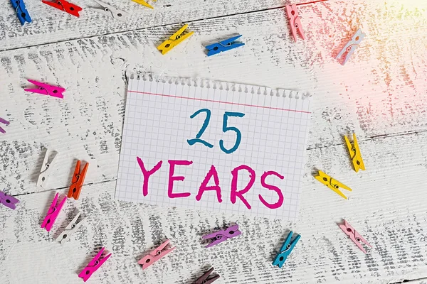 Woord schrijven tekst 25 Jaar. Zakelijk concept voor het Herinneren of eren van speciale dag voor het zijn 25 jaar in het bestaan Gekleurde wasknijper rechthoek vierkante vorm papier wit hout achtergrond. — Stockfoto