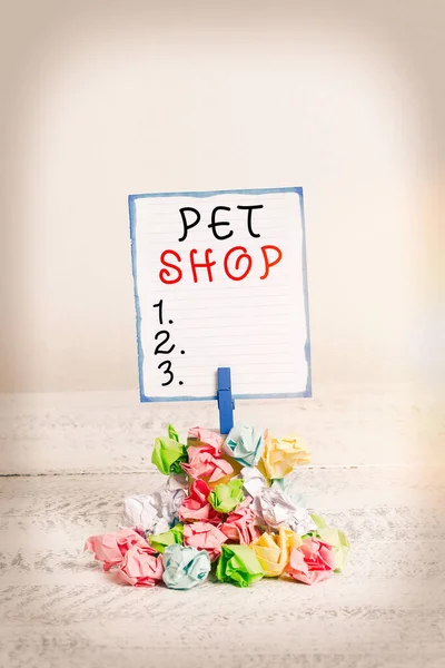 Testo calligrafico Pet Shop. Concetto significato Commercio al dettaglio che vende diversi tipi di animali al pubblico Promemoria mucchio colorato carta spiegazzata clothespin promemoria spazio in legno bianco . — Foto Stock