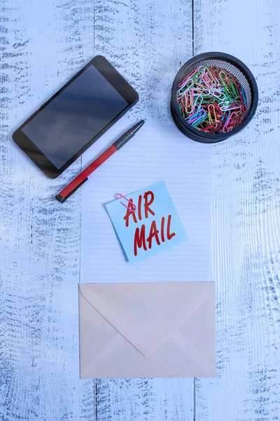 Ordskrivning text Air Mail. Affärsidé för påsar med brev och paket som transporteras med flygplan Smartphone papper ark clips hållare penna kuvert anteckning trä bakgrund. — Stockfoto