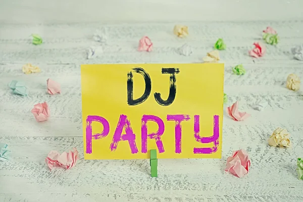 Znak tekstowy pokazujący DJ Party. Koncepcyjne zdjęcie pokazujące, kto wprowadza i odtwarza nagraną muzykę popularną w radiu Green clothespin white wood background colored paper reminder office supply. — Zdjęcie stockowe