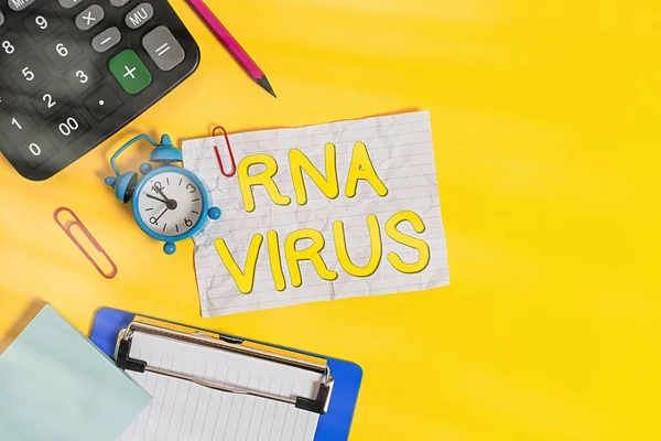 Writing note showing Rna Virus. Business photo showcasing a virus genetic information is stored in the form of RNA Alarm clock crushed note calculator pencil clipboard color background.