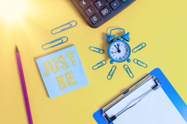 Skriva lapp som visar Just Be. Business foto showcasing att göra de saker du tror på och vill bli accepterad för väckarklocka urklipp penna kalkylator anteckningsblock färgad bakgrund. — Stockfoto