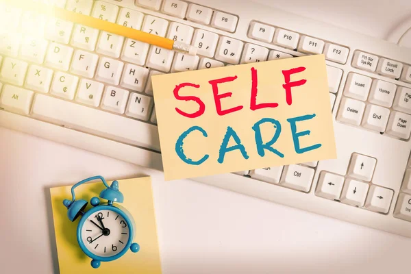 Writing note showing Self Care. Business photo showcasing practice of taking action preserve or improve ones own health Flat lay above empty note paper on the pc keyboard pencils and clock. — Stock Photo, Image