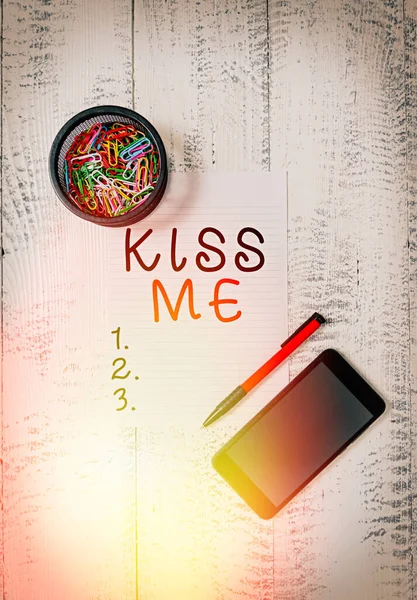 Sinal de texto mostrando Kiss Me. Foto conceitual solicitar informalmente para tocar meus lábios com seus lábios ou pressione contra Smartphone clipes de folha de papel titular esferográfica de madeira vintage fundo . — Fotografia de Stock