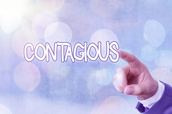 Escribiendo una nota que muestra Contagious. Foto comercial que muestra transmisible por contacto directo o indirecto con alguien infectado . —  Fotos de Stock