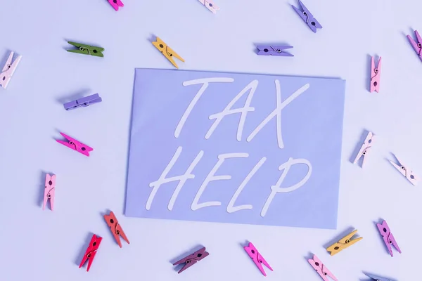 税金のヘルプが表示されます。概念的な写真国家収入への強制的な貢献からの援助色の布の四角形の形をしたリマインダー紙ライトブルーの背景. — ストック写真