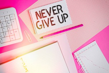 Kelime yazma metni asla pes etme. Renkli düz masa üzerine yerleştirilen yazma ekipmanları ve bilgisayar malzemelerinin durumunu iyileştirmeye çalışmaya devam etmek için iş kavramı.