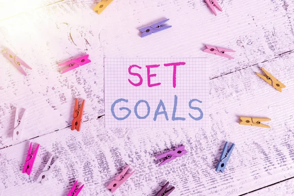 Text sign showing Set Goals. Conceptual photo Defining or achieving something in the future based on plan Colored clothespin rectangle square shaped paper white wood background. — Stock Photo, Image