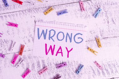 Kelime yazma metni yanlış yönde. Uygun olmayan ya da istenmeyen bir davranış ya da yön almak için iş konsepti Renkli mandal dikdörtgen kare kağıt beyaz ahşap arka plan.