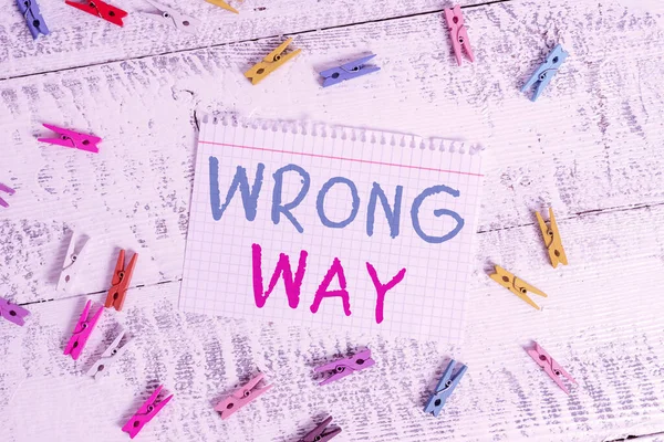 Word writing text Wrong Way. Business concept for taking an unsuitable or undesirable manners or direction Colored clothespin rectangle square shaped paper white wood background.