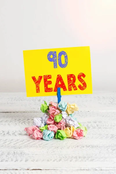 Texto de caligrafia 90 anos. Conceito significado Lembrar ou honrar dia especial por ter 90 anos de existência Lembrete pilha colorido papel enrugado pano lembrete espaço em madeira branca . — Fotografia de Stock