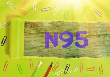 N95 'i gösteren bir not yazıyorum. Giyeni korumak için kullanılan kişisel koruma ekipmanlarını gösteren iş fotoğrafı..