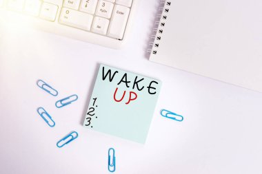 Mesaj işareti Uyanın 'ı gösteriyor. Kavramsal fotoğraf uyanma ya da uyanma örneği. Bilgisayarın klavyesinin yanındaki beyaz arka planda fotokopi alanı ile birlikte boş bir not kağıdı uyandır..