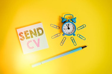 Gönder Cv 'i gösteren not yazılıyor. İş fotoğrafı gösterim kartı, iş için özel yetenek ve becerileri tanımlamak için geri dönün Metal alarm saati uyandırma klipleri tükenmez kalem renkli arkaplan.