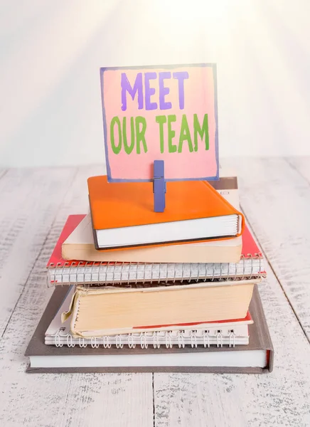 Writing note showing Meet Our Team. Business photo showcasing introducing another demonstrating to your team mates in the company pile stacked books notebook pin color reminder white wooden.