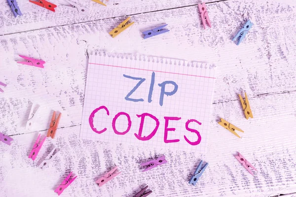 Szövegírás Zip kódok. Üzleti fogalom számok hozzáadott postai címet, hogy segítse a válogatás mail Színes ruhacsap téglalap alakú papír fehér fa háttér. — Stock Fotó