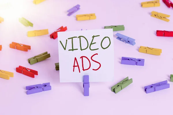 Text sign showing Video Ads. Conceptual photo Engage audience in the form of video content advertising Colored clothespin papers empty reminder white floor background office. — Stock Photo, Image