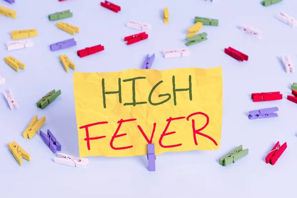 Handwriting text writing High Fever. Concept meaning medical condition which the body temperature higher than usual Colored clothespin papers empty reminder blue floor background office pin.