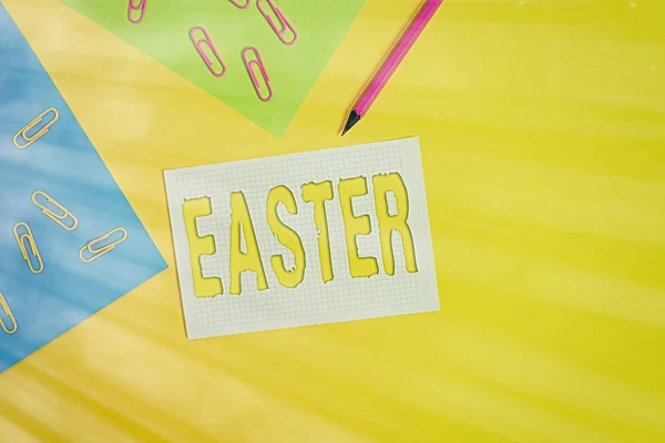 Parola di scrittura del testo Pasqua. Business concept per il festival più importante e più antico della Chiesa cristiana Fogli di carta bianchi quadratino quadratino matita clip fondo colorato pianura . — Foto Stock