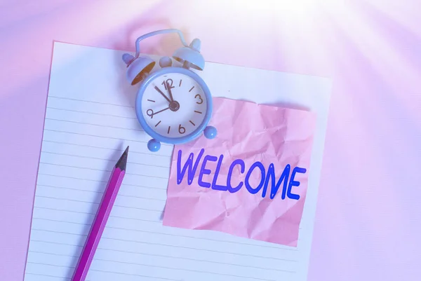 Texto de escritura de palabras Bienvenido. Concepto de negocio por ejemplo o manera de saludar a alguien de manera educada o amigable Lápiz de hoja de papel rayado reloj despertador vintage color fondo . — Foto de Stock