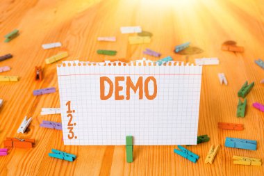 Demo 'yu gösteren kavramsal el yazısı. Bir ürün teknikleri ve becerilerinin tanıtımını gösteren iş fotoğrafı. Renkli kağıtlar, ahşap zemin çamaşır mandalı..