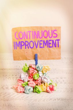 Metin işareti sürekli gelişim gösteriyor. Kavramsal fotoğraf Hiç bitmeyen İlerleme Çabası Hatırlatma yığın Renkli kağıt çamaşır tokası beyaz ahşap uzayı hatırlatma.