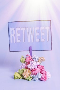 Retweet 'i gösteren bir not yazıyorum. İş fotoğrafı görüntüsü twitter sunucusu veya iletisi başka bir kullanıcı yığını hatırlatıcı renkli buruşuk kağıt çamaşır tokası ahşap boşluk iletisi.
