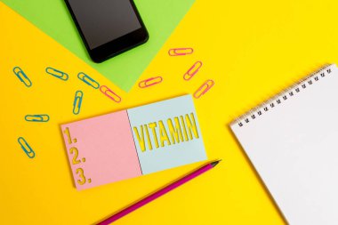 Vitamini gösteren bir not yazıyorum. Normal büyüme alanı boş notlar, kalem akıllı telefon sayfası renk arkaplanı için gerekli olan organik bileşikleri gösteren iş fotoğrafı..