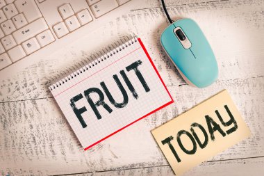 Fruit 'u gösteren bir not yazıyorum. Tohum yazma ekipmanları ve bilgisayar malzemelerini ahşap masaya koyan bir ağacın ya da diğer bitkinin tatlı ve etli ürünlerini gösteren iş fotoğrafı..